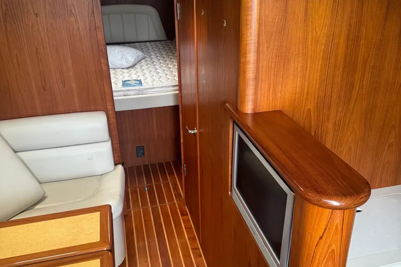 Slide: The Image of 2004 Tiara Yachts 4200 Open interior with wood paneling, bed, and seating area. - 48