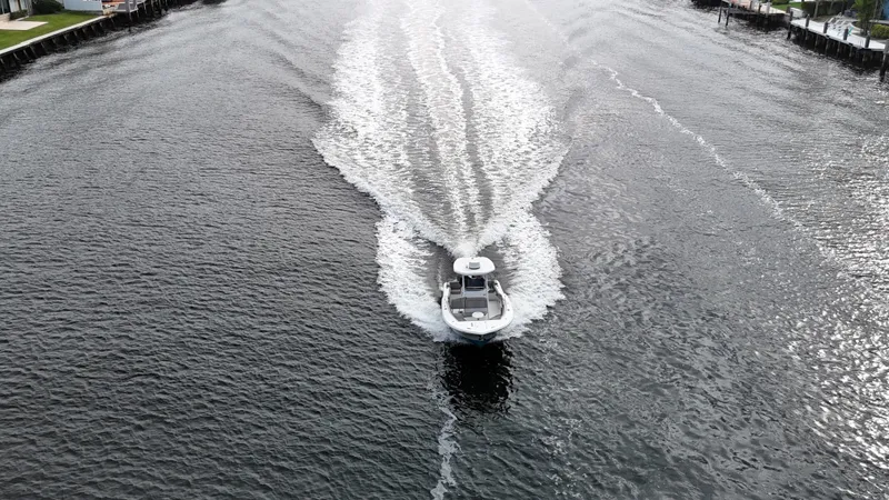 Slide: The Image of Aerial view of 2017 Tidewater 252 LXF boat cruising on a wide waterway. - 17