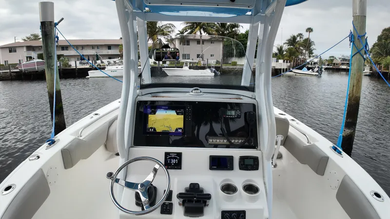 Slide: The Image of 2017 Tidewater 252 LXF boat dashboard with navigation equipment, docked in a canal. - 23