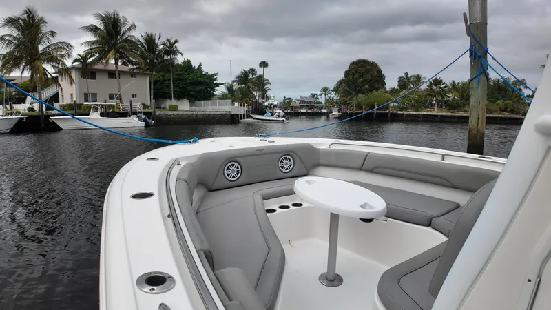Slide: The Image of 2017 Tidewater 252 LXF boat with seating area, docked near palm trees and waterfront homes. - 25
