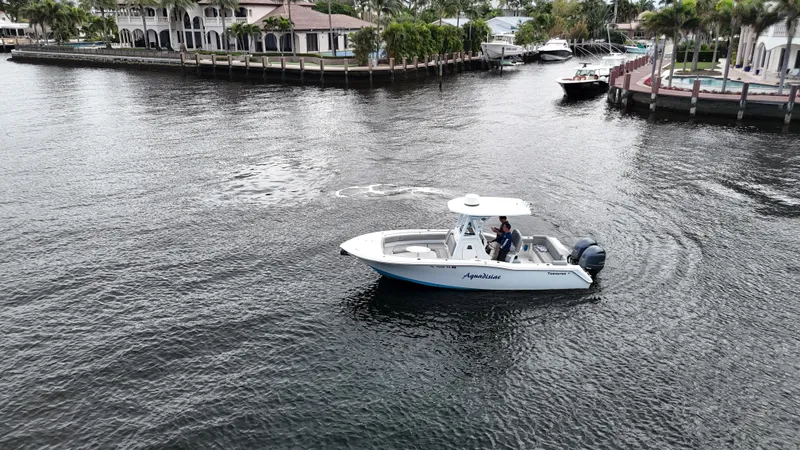 Slide: The Image of 2017 Tidewater 252 LXF boat cruising near waterfront homes. - 3