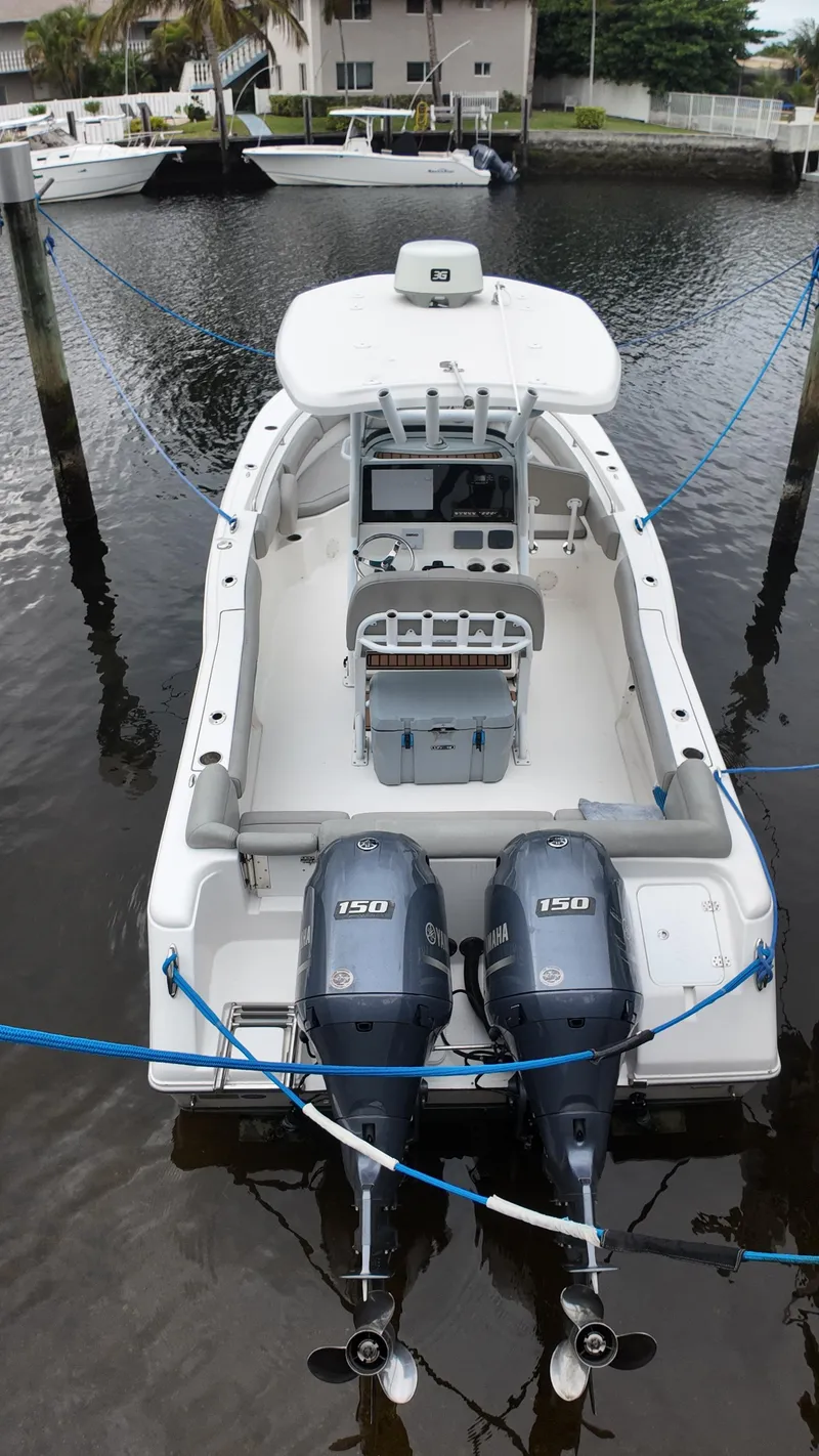 Slide: The Image of 2017 Tidewater 252 LXF boat with dual engines docked in a marina. - 37