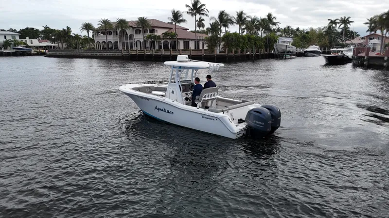 Slide: The Image of 2017 Tidewater 252 LXF boat cruising on a scenic waterway with palm trees. - 5