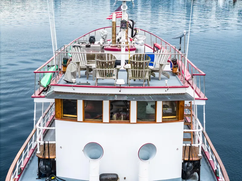 Slide: The Image of 1941 Custom Sagstad Fantail boat with deck chairs, docked on calm water. - 12