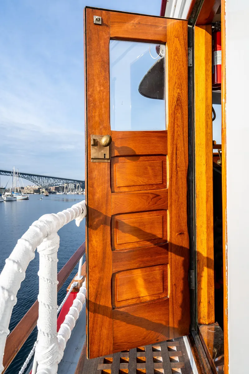 Slide: The Image of Wooden door on 1941 Custom Sagstad Fantail boat, open to scenic waterfront view. - 18