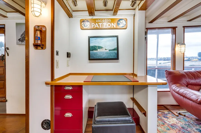 Slide: The Image of Interior of 1941 Custom Sagstad Fantail boat with desk, artwork, and red leather seating. - 31