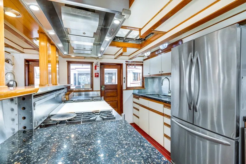 Slide: The Image of 1941 Custom Sagstad Fantail kitchen with modern appliances, stainless steel fridge, and granite countertops. - 36