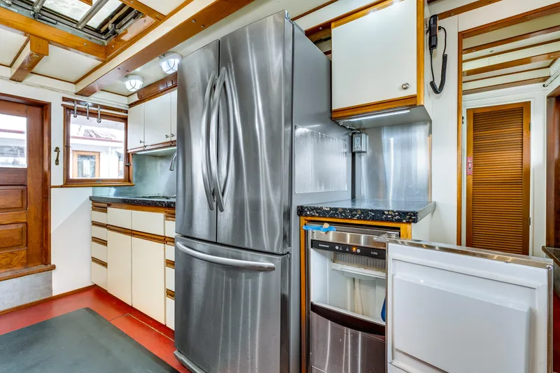 Slide: The Image of Modern kitchen inside a 1941 Custom Sagstad Fantail boat, featuring stainless steel appliances. - 37