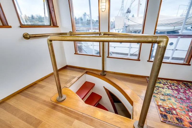 Slide: The Image of Staircase with brass railing on 1941 Custom Sagstad Fantail boat, featuring wooden flooring and colorful rug. - 42