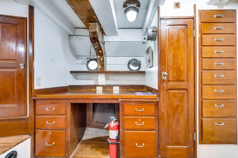 Slide: The Image of 1941 Custom Sagstad Fantail interior with wooden cabinetry, desk, and portholes. - 46