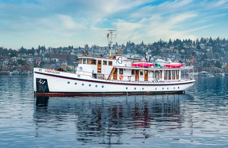 Slide: The Image of 1941 Custom Sagstad Fantail boat on calm water with cityscape background. - 6
