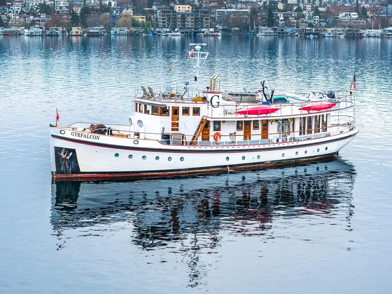 Slide: The Image of 1941 Custom Sagstad Fantail boat on calm water, reflecting cityscape background. - 7