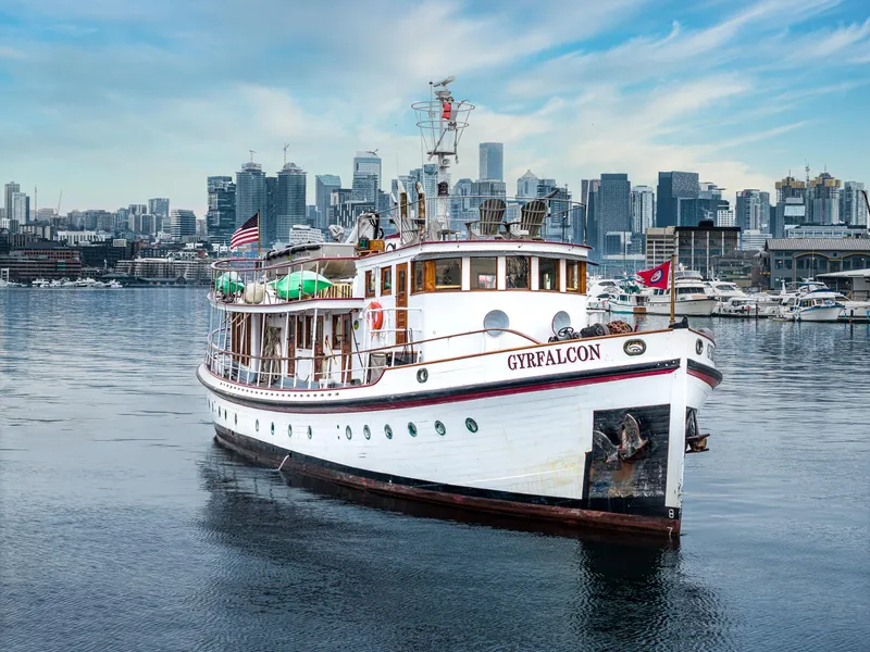 Slide: The Image of 1941 Custom Sagstad Fantail yacht "Gyrfalcon" on water with city skyline backdrop. - 9