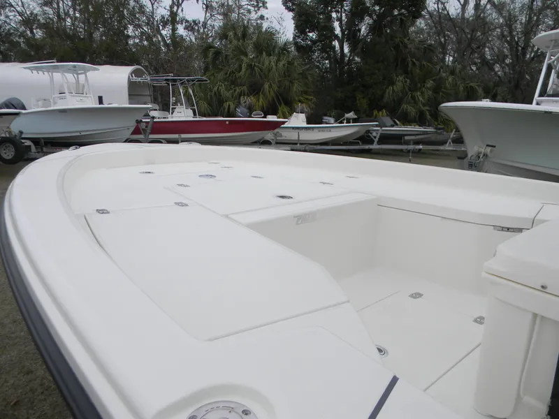 Slide: The Image of 2025 Pathfinder 2200 TRS boat, white deck, parked among other boats, outdoor setting. - 5