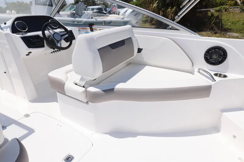Slide: The Image of 2025 Hurricane SunDeck 235 OB boat interior with white and gray seating, steering wheel, and speaker. - 13