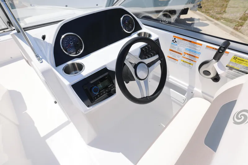 Slide: The Image of 2025 Hurricane SunDeck 235 OB boat dashboard with steering wheel and controls. - 20