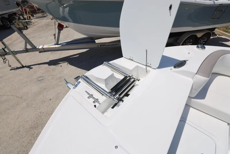 Slide: The Image of 2025 Hurricane SunDeck 235 OB boat with open storage compartment and ladder. - 24