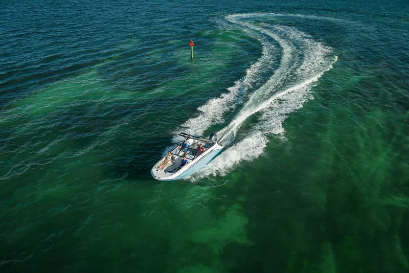 Slide: The Image of 2025 Hurricane SunDeck 235 OB cruising on clear green waters. - 33