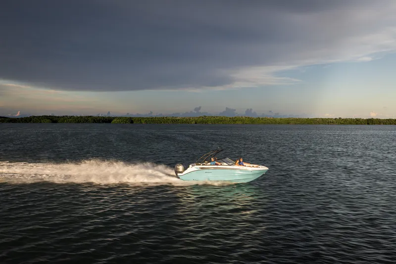 Slide: The Image of 2025 Hurricane SunDeck 235 OB speeding on open water under cloudy sky. - 37
