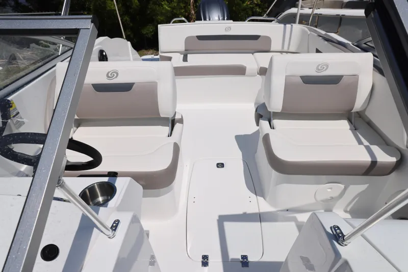 Slide: The Image of 2025 Hurricane SunDeck 235 OB boat interior with white seating and steering wheel. - 5