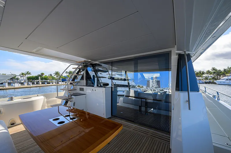 Slide: The Image of Prestige 690 yacht deck with wooden table, marina view, 2021 model. - 18