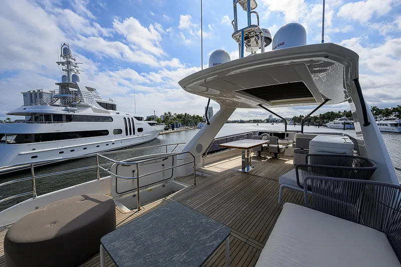 Slide: The Image of Luxurious 2021 Prestige 690 yacht deck with seating, docked near another yacht. - 27