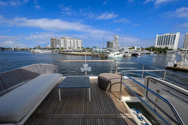 Slide: The Image of Prestige 690 yacht deck with marina view, 2021 model, featuring seating and table. - 30