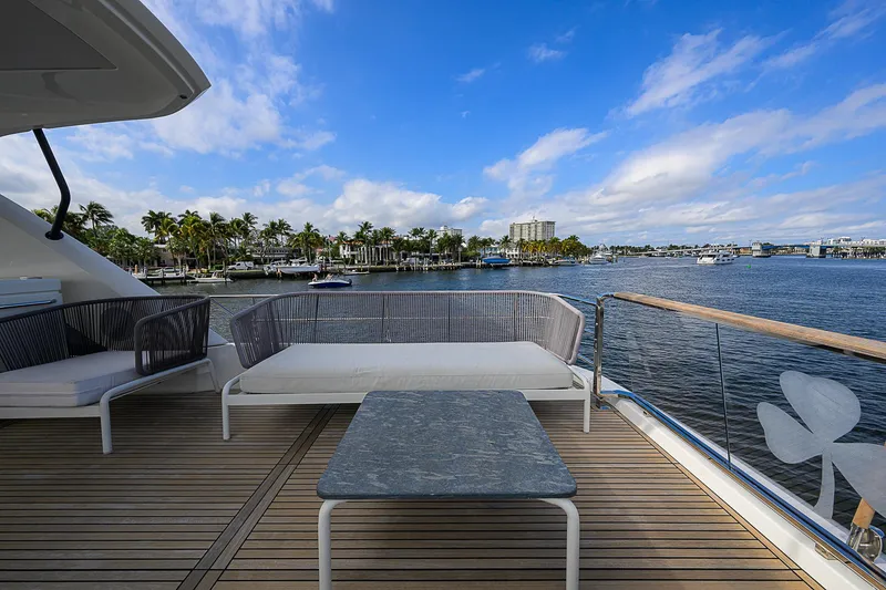 Slide: The Image of Prestige 690 yacht deck with seating, overlooking scenic waterfront, 2021 model. - 31