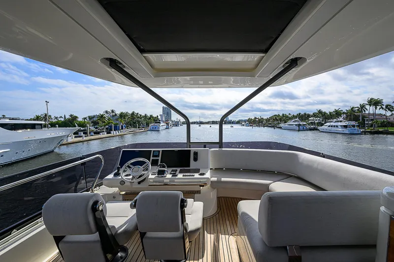 Slide: The Image of Luxurious 2021 Prestige 690 yacht interior with helm, seating, and scenic marina view. - 35