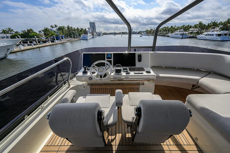 Slide: The Image of Prestige 690 yacht helm, 2021 model, with luxurious seating and scenic marina view. - 39