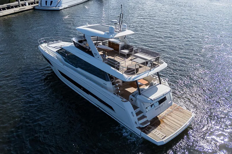 Slide: The Image of Luxury 2021 Prestige 690 yacht cruising on water, showcasing elegant design and spacious decks. - 7