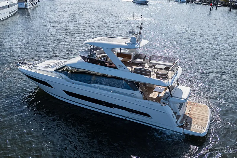 Slide: The Image of Luxury 2021 Prestige 690 yacht cruising on open water. - 8