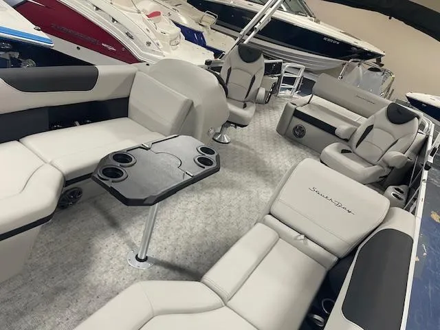 Slide: The Image of Luxurious 2025 South Bay 200 pontoon boat interior with plush seating and table. - 13