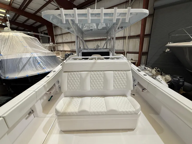 Slide: The Image of 2022 Invincible 39 Open Fisherman boat with white seating in a storage facility. - 21