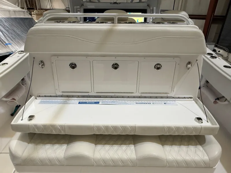 Slide: The Image of 2022 Invincible 39 Open Fisherman boat seating and storage area, featuring white cushioned seats. - 22