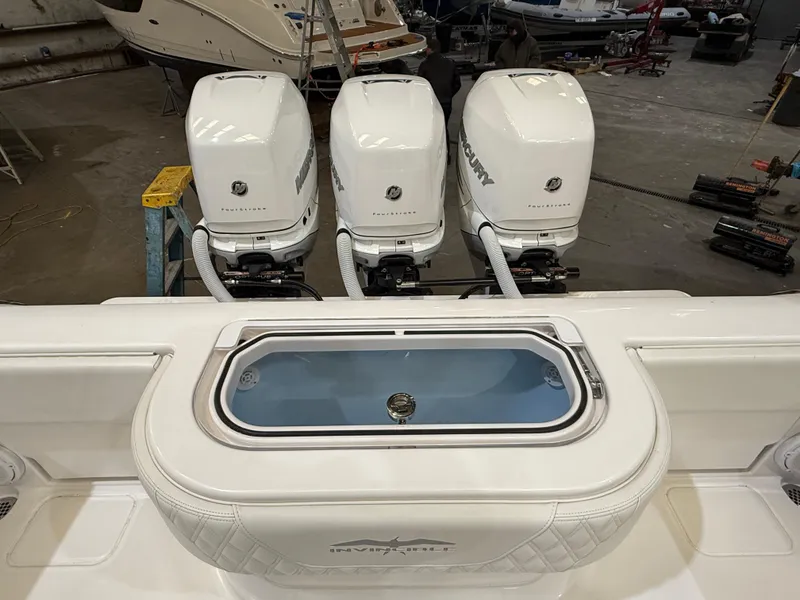 Slide: The Image of 2022 Invincible 39 Open Fisherman with triple Mercury outboard engines in a showroom. - 37