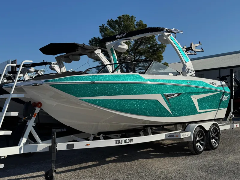 The Image of 2025 Tigé 22RZX boat with teal and white design on a trailer. - 0