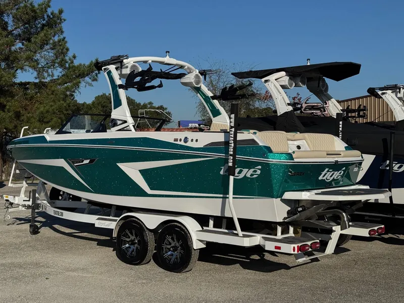 Slide: The Image of 2025 Tigé 22RZX boat with green and white design on a trailer. - 2