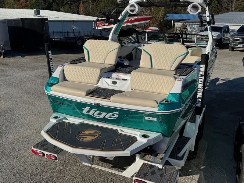 Slide: The Image of 2025 Tigé 22RZX boat with beige seating and teal accents, parked outdoors. - 3
