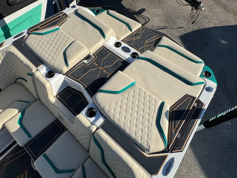 Slide: The Image of 2025 Tigé 22RZX boat interior with beige and teal seating, diamond stitching, and cup holders. - 4