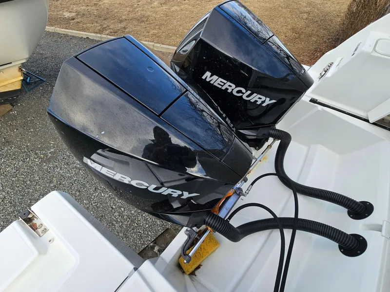 Slide: The Image of Twin Mercury outboard engines on a 2020 Beneteau Antares 9 boat, parked on pavement. - 15