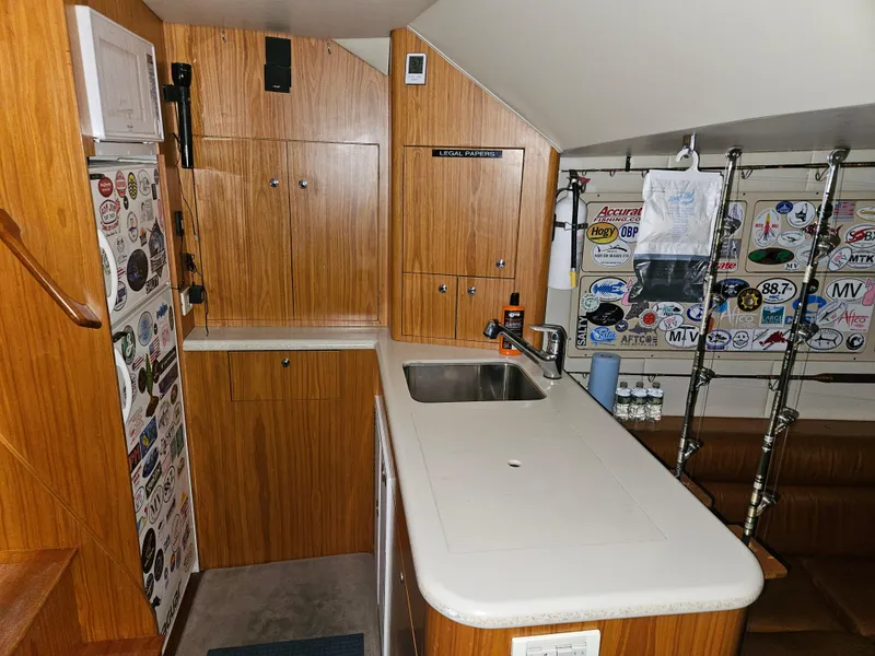 Slide: The Image of Interior of 2001 Davis 45 Express boat with wooden cabinetry and fishing rod holders. - 13
