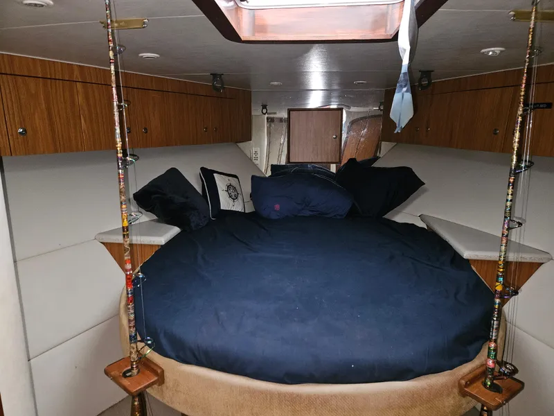 Slide: The Image of Interior cabin of 2001 Davis 45 Express boat with cozy bedding and fishing rods. - 14