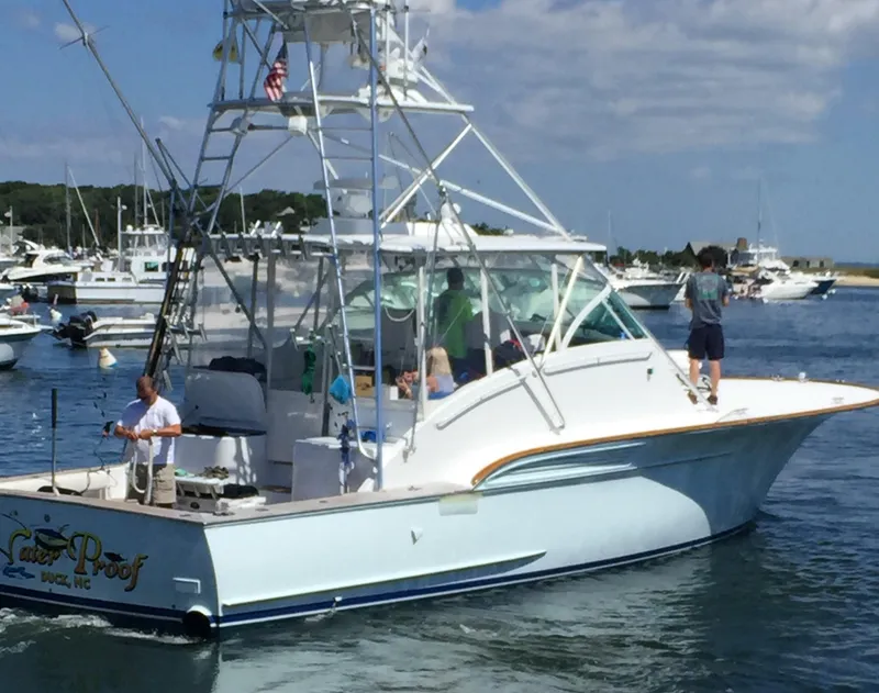 Slide: The Image of 2001 Davis 45 Express boat on water, people onboard, marina background. - 3