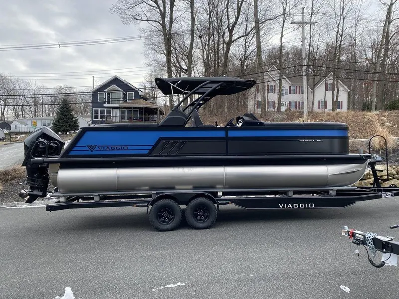 Slide: The Image of 2025 Viaggio D24U pontoon boat on trailer, parked on a suburban street. - 7