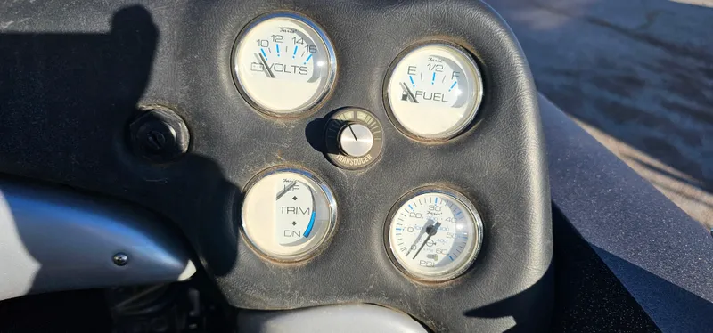 Slide: The Image of Dashboard gauges of a 2009 Stratos 201 XL boat, showing volts, fuel, trim, and speed. - 13