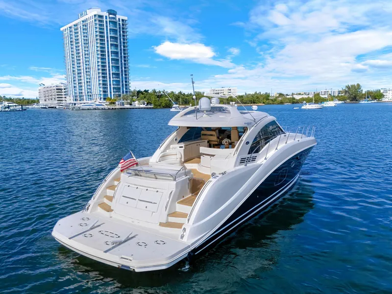 Slide: The Image of 2009 Sea Ray 55 Sundancer yacht on water with cityscape background. - 2