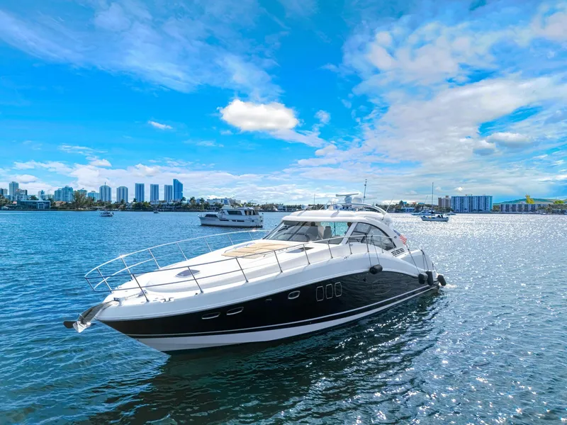 Slide: The Image of 2009 Sea Ray 55 Sundancer yacht on a sunny day, city skyline in background. - 3