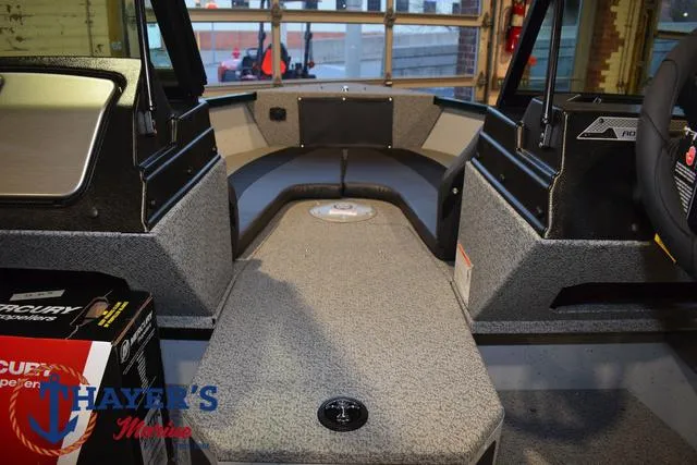 Slide: The Image of 2025 Lund 1675 Adventure Sport boat interior with gray carpet and seating. - 10