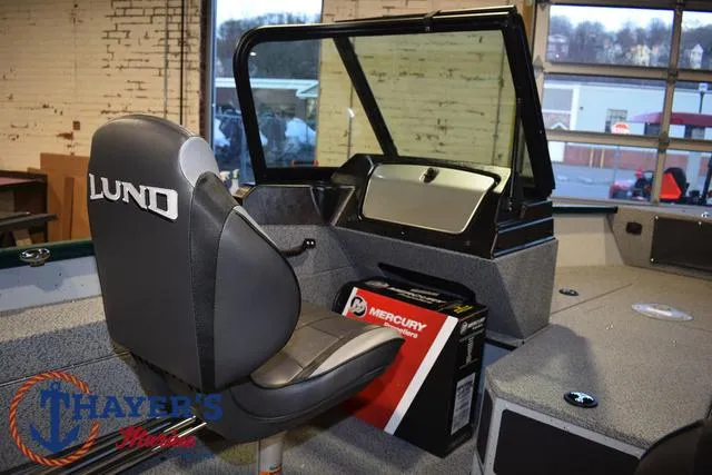Slide: The Image of 2025 Lund 1675 Adventure Sport boat interior with Mercury box and branded seat. - 19
